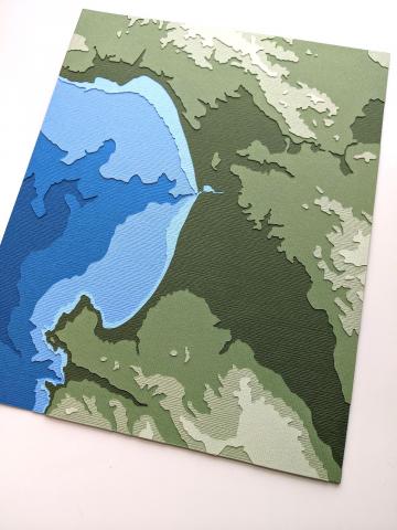 photo of layered papercut artwork depicting Monterey Bay, California