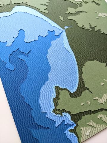 photo of layered papercut artwork depicting Monterey Bay, California