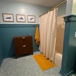 three framed lake pieces on a wall in a bathroom