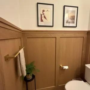 two framed pieces in a brown and cream powder room