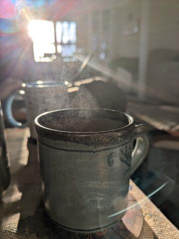 steam rising out of a coffee mug with morning sun
