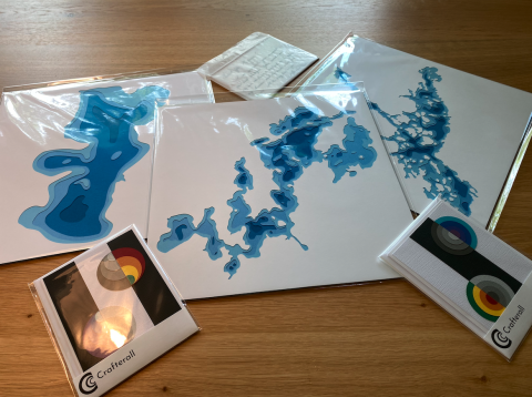 packaged papercut art pieces with cards on a table