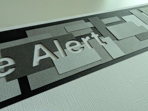 a layered cut paper piece in shades of grey and black